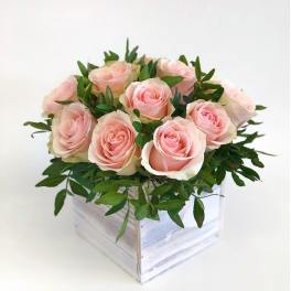 Pink roses arranged in a white wooden box