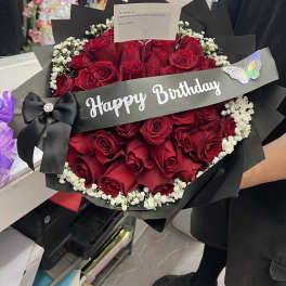 Bouquet of red roses with baby's breath and a Happy Birthday ribbon