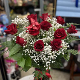 Bouquet of red roses with white baby's breath and a pink butterfly pick
