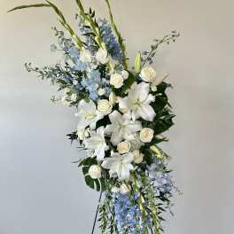 Tall white and blue floral standing arrangement on a black easel