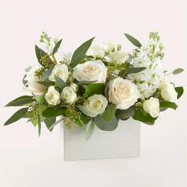 White roses and white blooms arranged in a white box