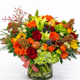 Bright mixed bouquet with roses, lilies, and gerbera daisies in a glass vase