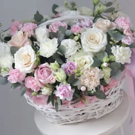 Pink and white roses with carnations in a white basket