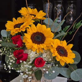 Sunflower and red rose arrangement in a birch-style container