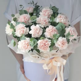 Bouquet of pale pink carnations with eucalyptus in a lavender box