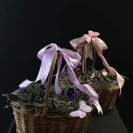 Two wicker baskets with small purple flowers and pastel ribbons