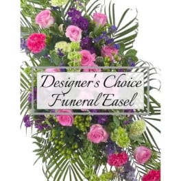 Funeral easel spray with pink roses, purple flowers, and greenery