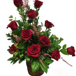 Basket arrangement of red roses with pink filler flowers