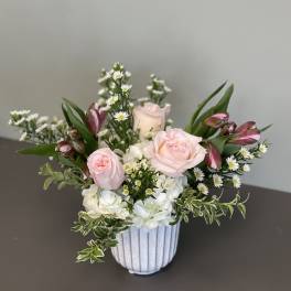 Pink roses and white hydrangeas in a white ribbed vase