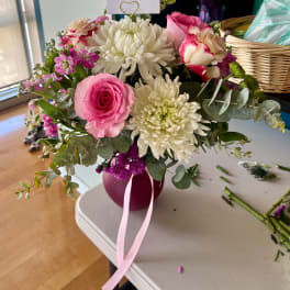 Pink and white mixed bouquet in a round vase with a ribbon