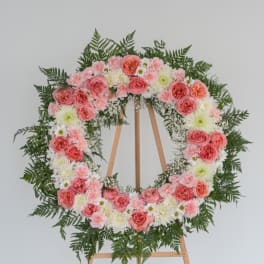 Pink and white floral wreath on a wooden easel