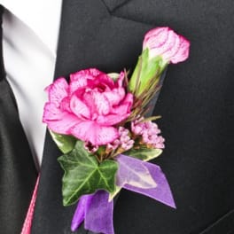 Pink boutonniere with ribbon on a black suit lapel