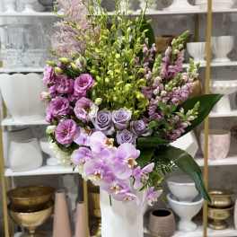 Lavender and pink floral arrangement in a white vase