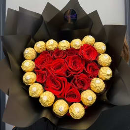 Heart-shaped bouquet of red roses and gold-wrapped chocolates in black paper