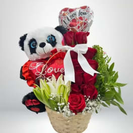 Basket arrangement with red roses, a panda plush, and heart balloons