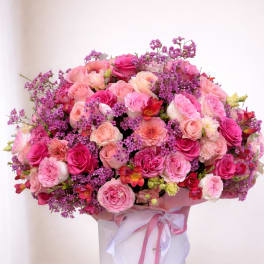 Large pink and purple rose bouquet in a white hat box with ribbon