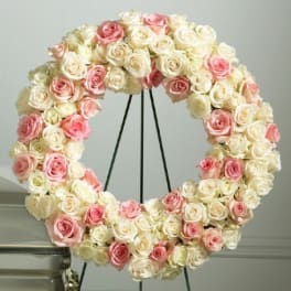 Circular wreath of pink and white roses on a stand