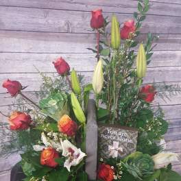 Mixed bouquet with red roses, lilies, and a sympathy card
