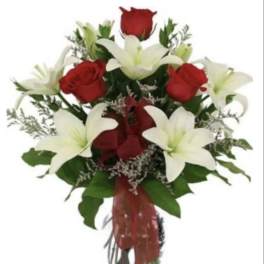 Bouquet of red roses and white lilies in a glass vase