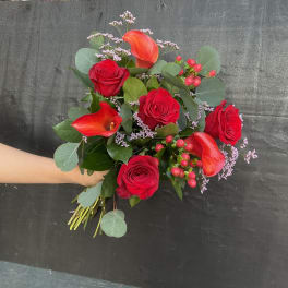 Bouquet of red roses and orange calla lilies with greenery