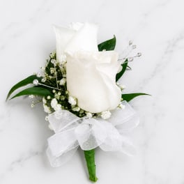 White rose boutonniere with baby's breath and a sheer ribbon