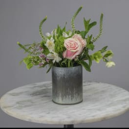 Pink roses and white flowers in a ribbed metal vase