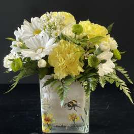 Yellow and white bouquet in a decorated glass vase