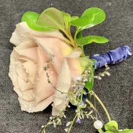Blush rose boutonniere with green leaves and blue ribbon