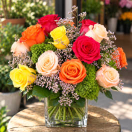 Colorful rose bouquet in a clear square vase