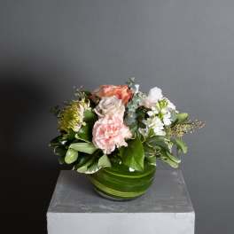 Mixed bouquet in a green glass bowl vase with pink and white flowers