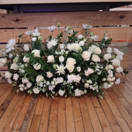 Large white floral arrangement with roses and daisy-like blooms