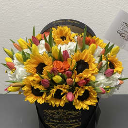 Bouquet of sunflowers, tulips, and white hydrangeas in a black hat box