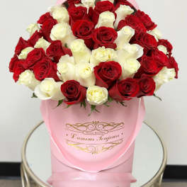 Bouquet of red and white roses in a pink hat box