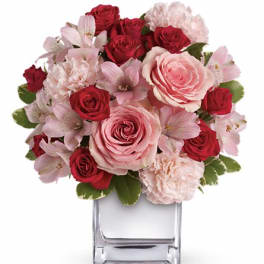 Pink and red rose bouquet in a clear square vase