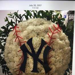 White floral wreath with a black Yankees logo and red stitching accents