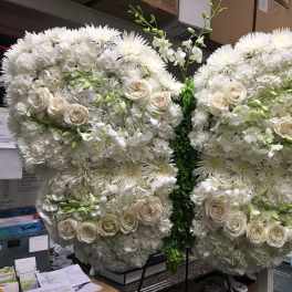 Large white floral butterfly display with roses and chrysanthemums