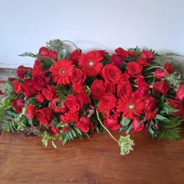 Long low arrangement of red roses and gerbera daisies