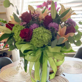 Mixed bouquet of lilies, roses, hydrangeas, and orchids in a vase