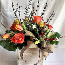 Orange roses in a rustic wooden box with a burlap bow