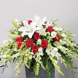 Red roses and white lilies arranged in a dark vase