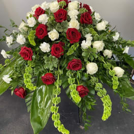 Large red and white rose arrangement with cascading greenery