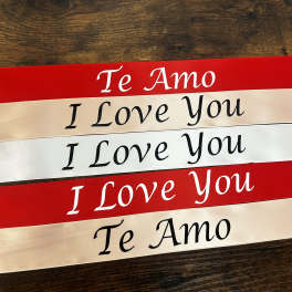 Stacked red and ivory ribbons printed with "Te Amo" and "I Love You"