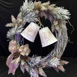 Decorative wreath with frosted branches, ribbon, pinecones, and hanging bells
