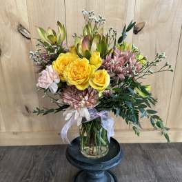 Bouquet of yellow roses and pink chrysanthemums in a glass vase