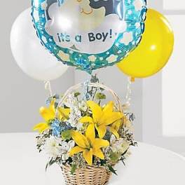 Yellow and white flower basket with it’s a boy balloon and colored balloons behind