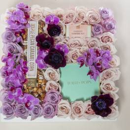 Floral gift box with pink and lavender roses and purple orchids around candy boxes