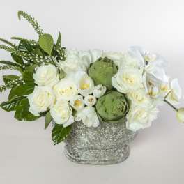 White roses and orchids in a textured gray vase