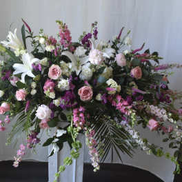 Large floral spray with pink and white flowers on a pedestal