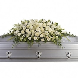 White floral casket spray on a gray casket