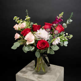 Bouquet of red and blush roses in a glass vase